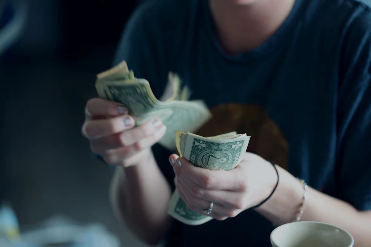 Person counting dollar bills with both hands