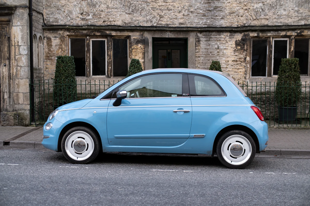 Small blue economy car parked on a street