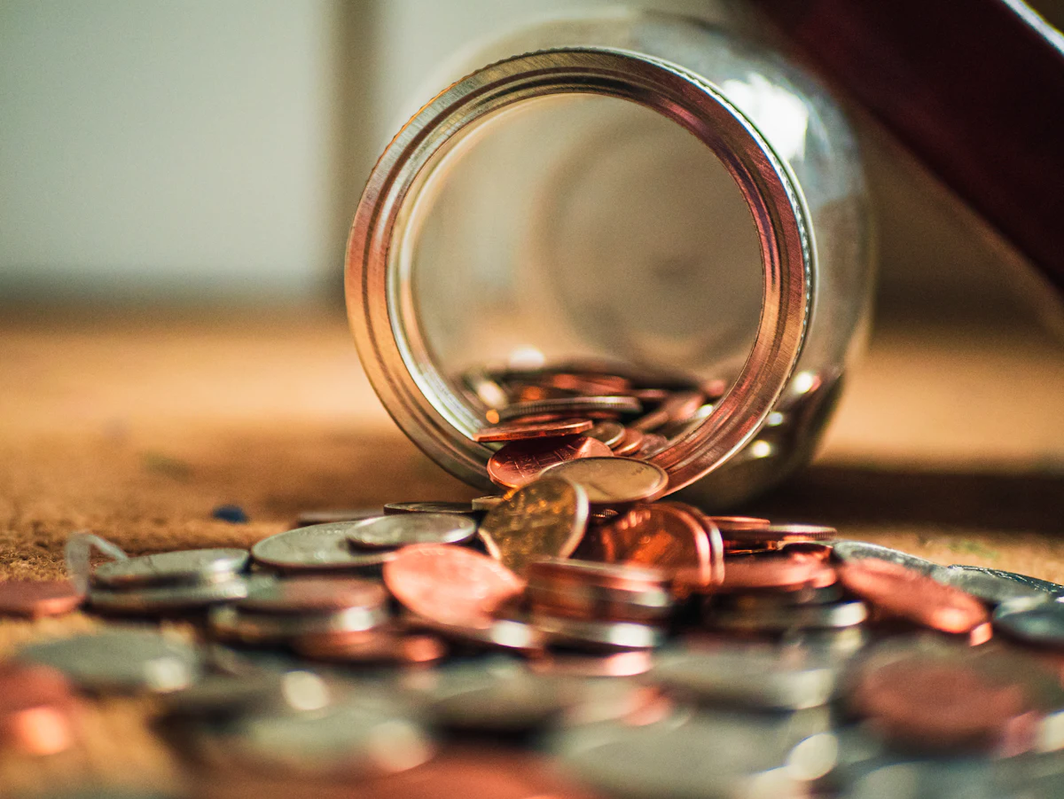 Jar of coins spilling onto a table