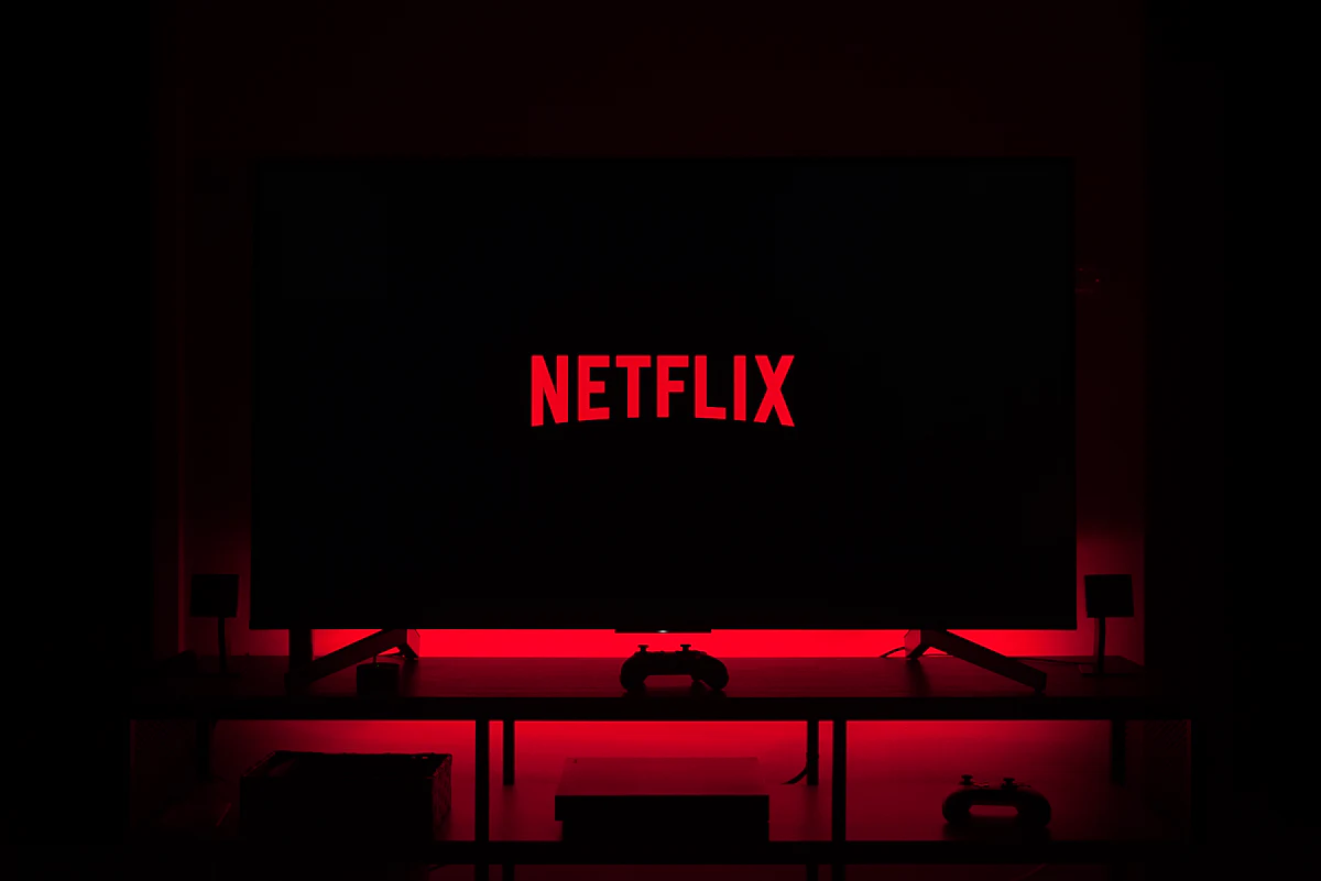 A Netflix logo glowing on a television in a dark room